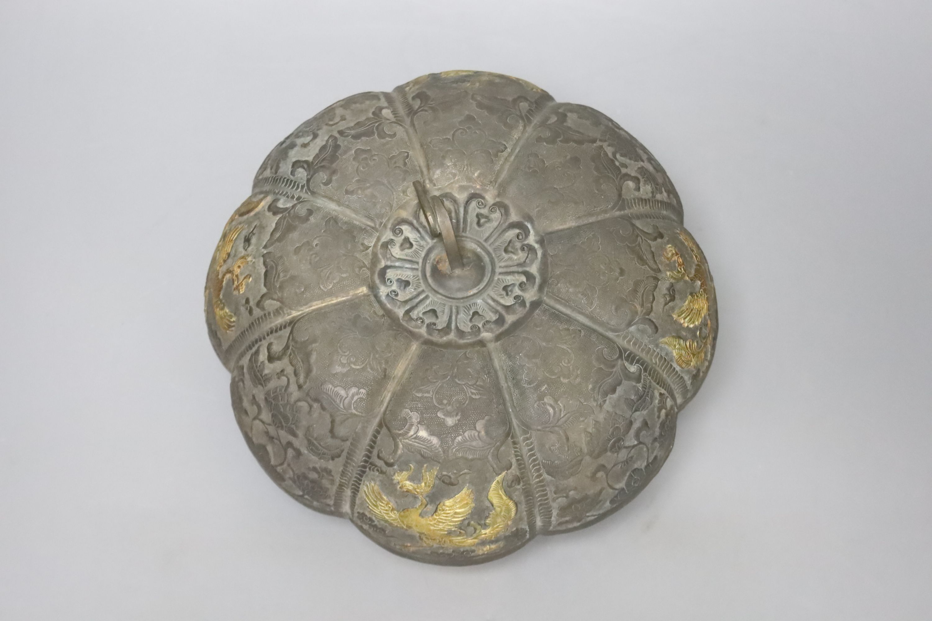 A 19th century Chinese melon-shaped silvered bronze box and cover, applied with gold figures of dragons in flight, Tang dynasty or later, 19cm diameter 10cm high